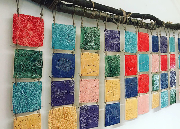 coloured and textured ceramic tiles hung on wall