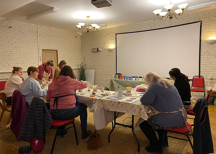 women sat around table attending a ceramic workshop