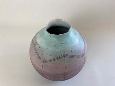 A handmade earthenware coiled pot, colored in cold purples and blues, with a grey gloss glaze on the interior, inspired by a sunrise on a cold winters morning. 
