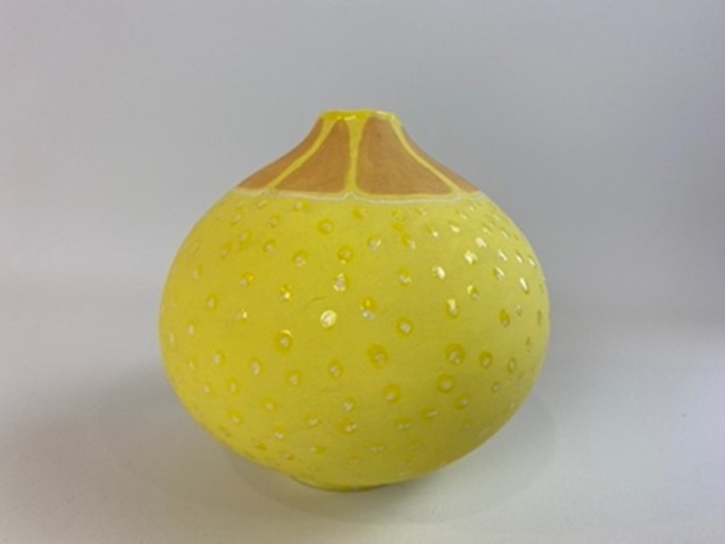 A handmade earthenware small vase, finished with a variety of techniques to resemble a lemon. 