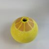 A handmade earthenware small vase, finished with a variety of techniques to resemble a lemon. 