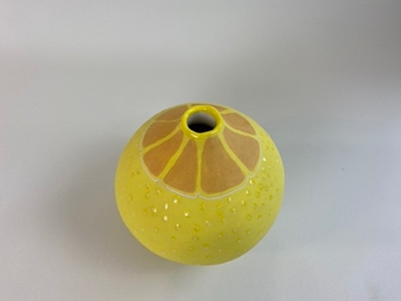 A handmade earthenware small vase, finished with a variety of techniques to resemble a lemon. 